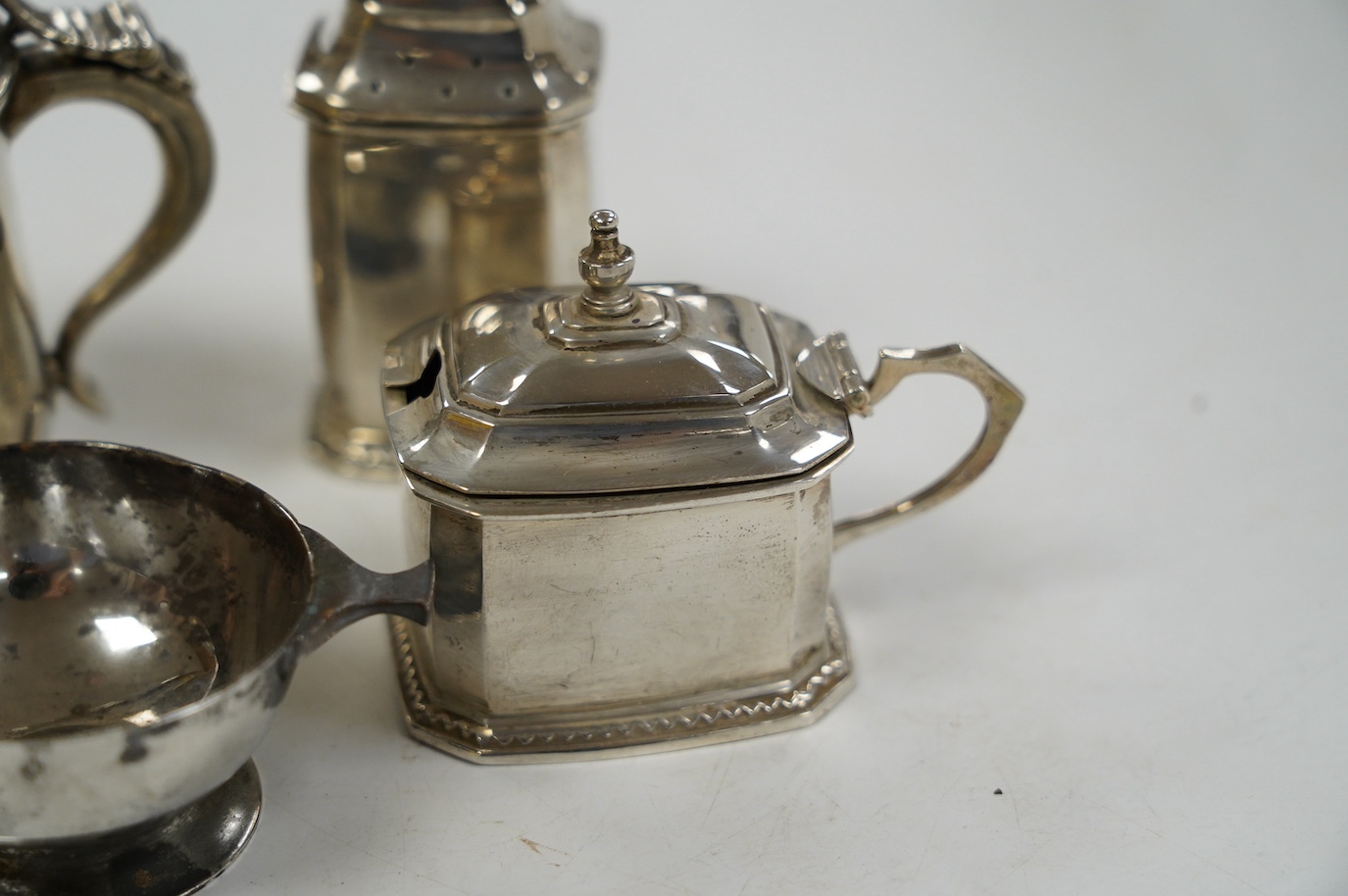 Five assorted silver condiments, including Chinese white metal modelled a rickshaw, together with a plated tea kettle stand with burner. Condition - poor to fair